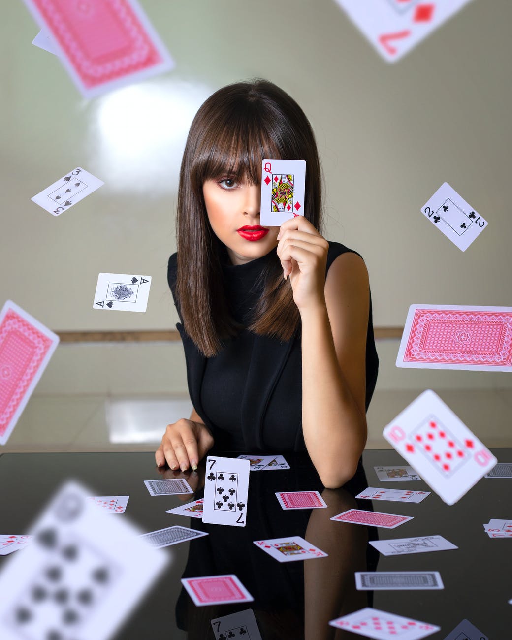woman covering face with playing card
