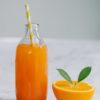 orange juice in clear glass bottle