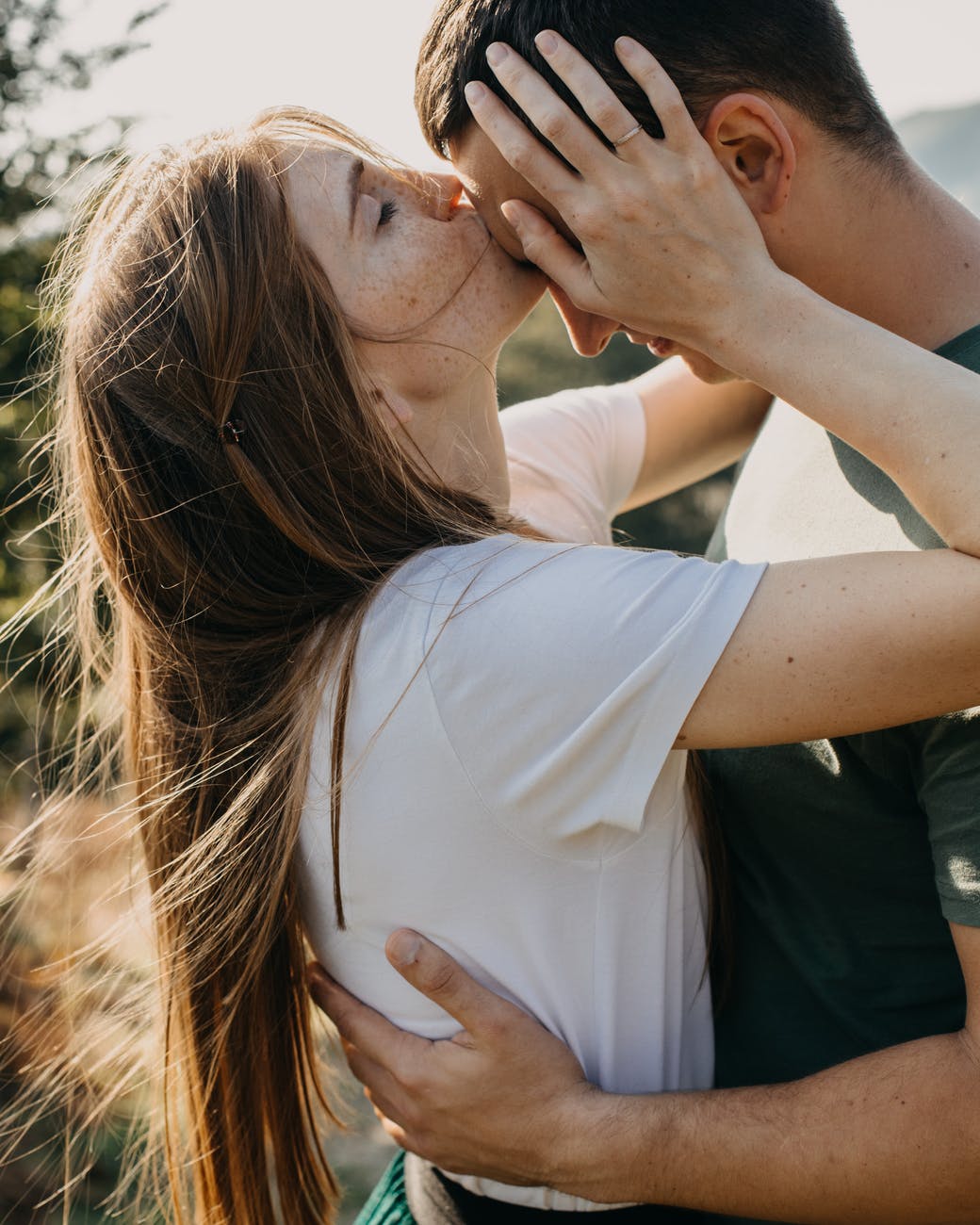 woman kissing boyfriend on forehead