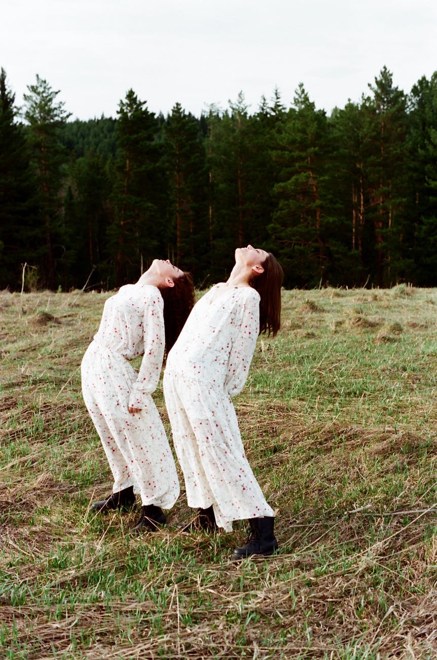 women in twinning clothes standing in the grass field
