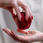 person holding red heart shaped ornament