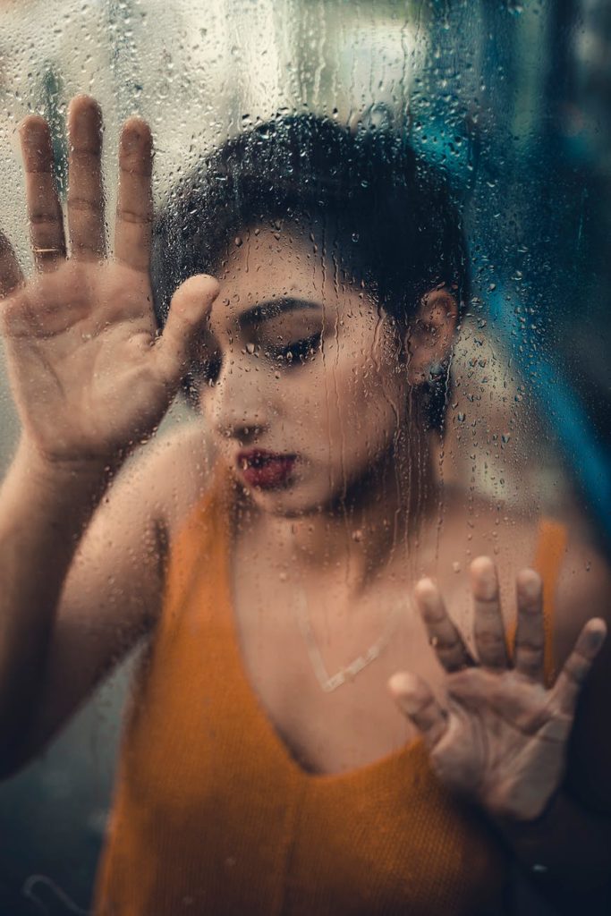 woman wearing tank top touching glass panel