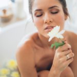 topless woman holding white flower