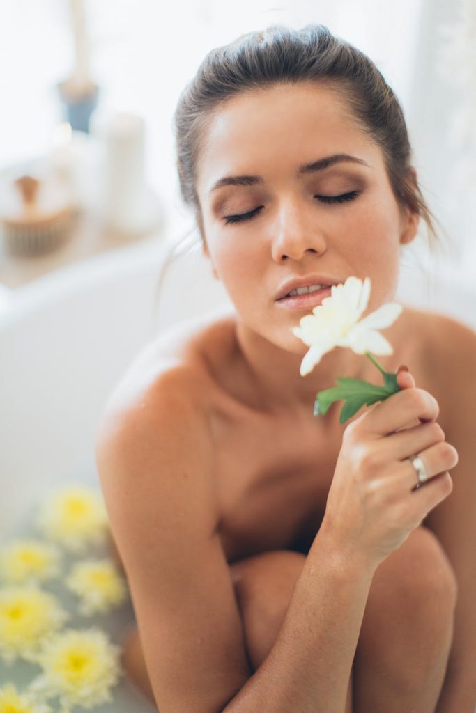 topless woman holding white flower