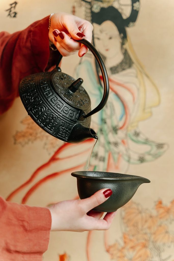 a person pouring hot water on a tea bowl