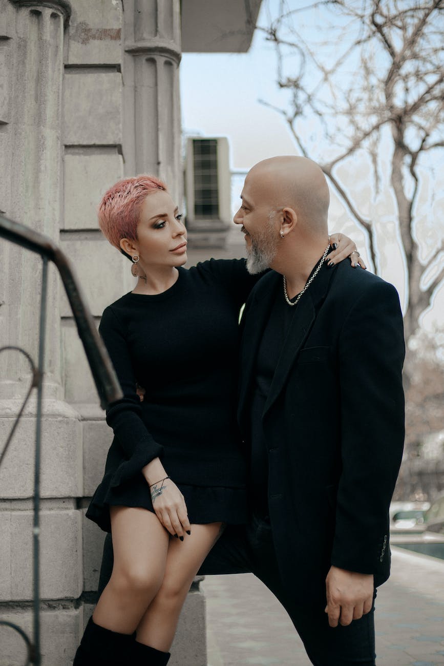 elegant fashionable couple in love standing near building