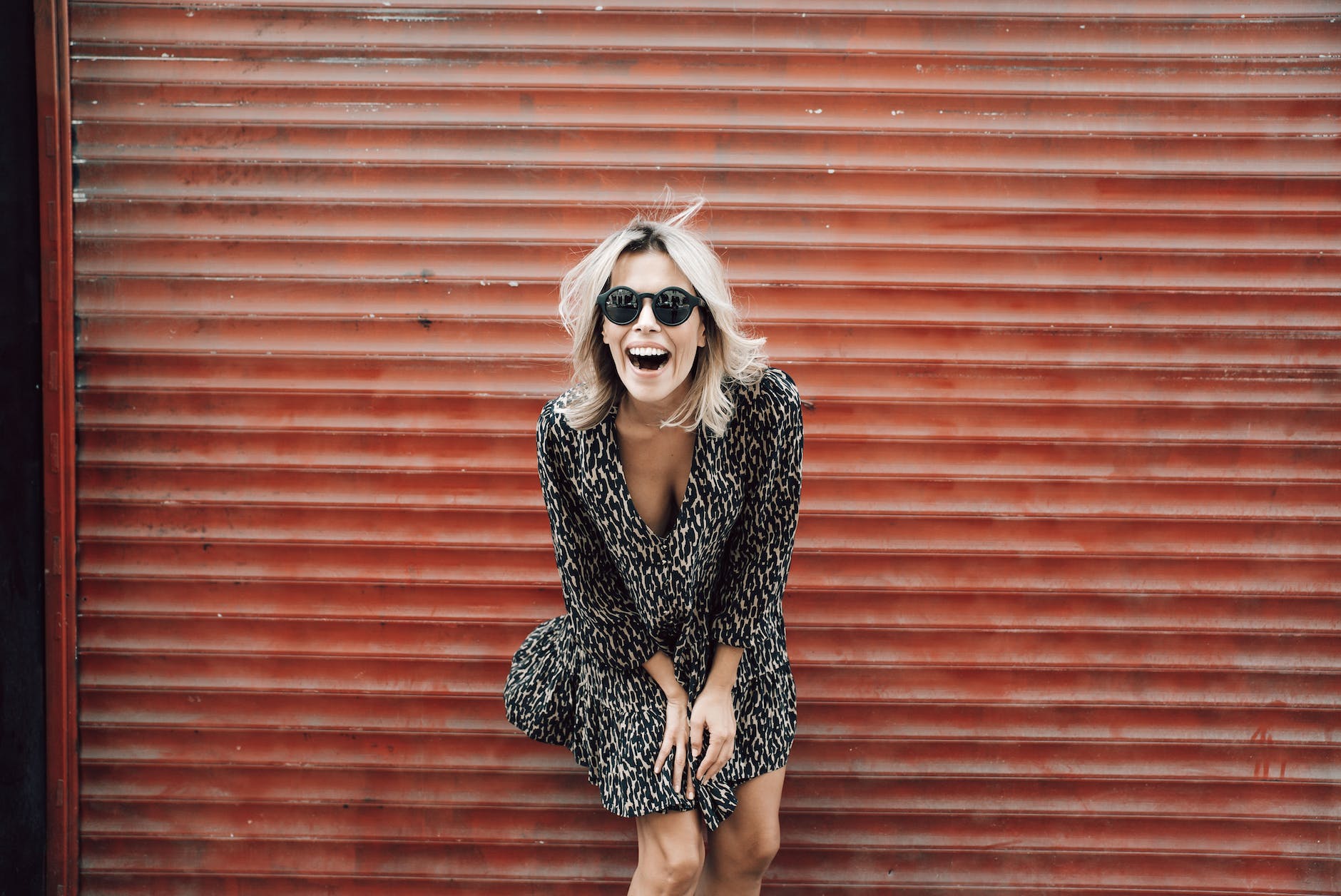 stylish positive woman in sunglasses laughing brightly
