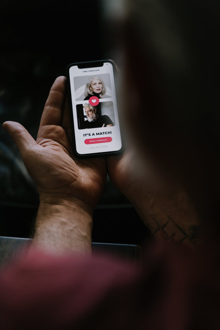 human hands holding a smartphone with dating matching app on screen