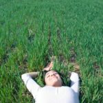woman laying on field of green grass