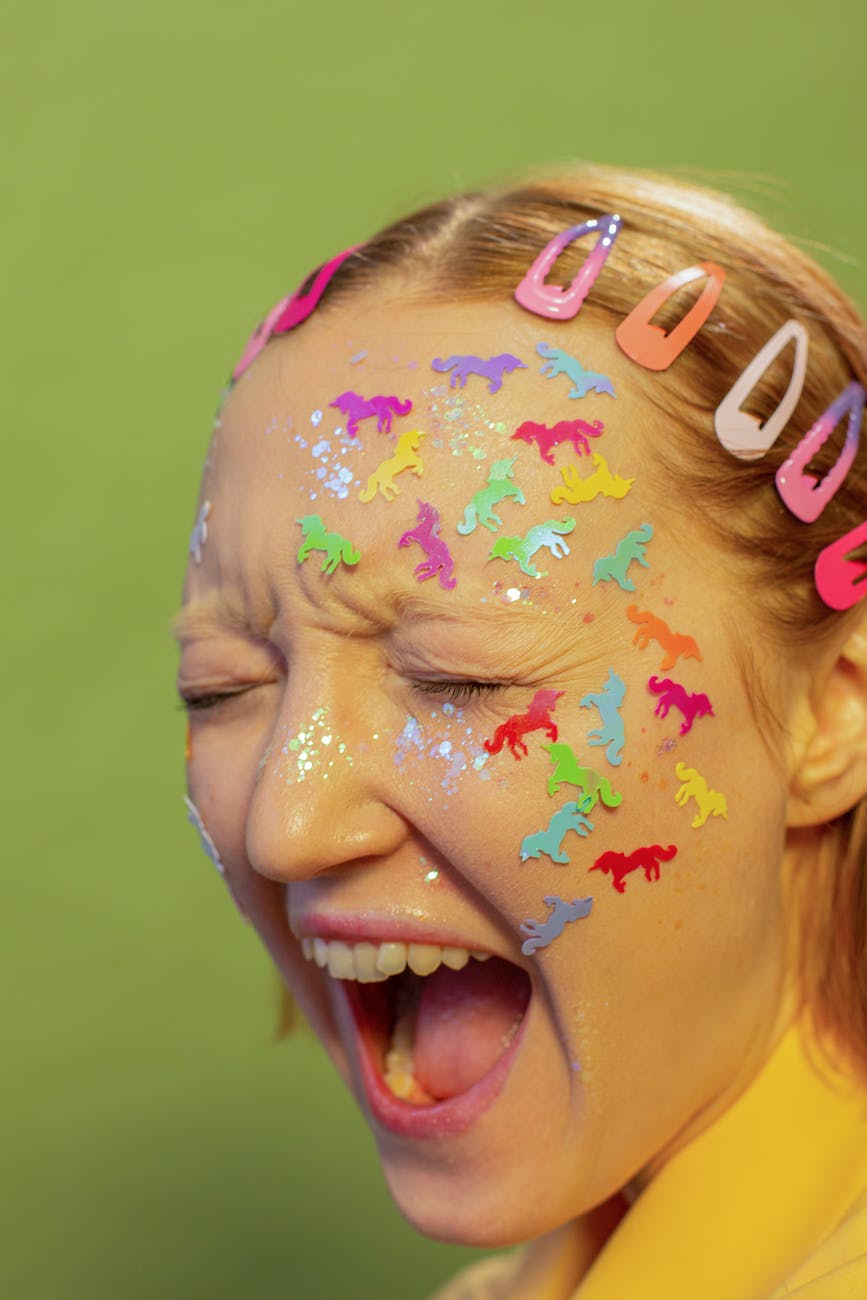 young woman with childish stickers on face shouting in studio