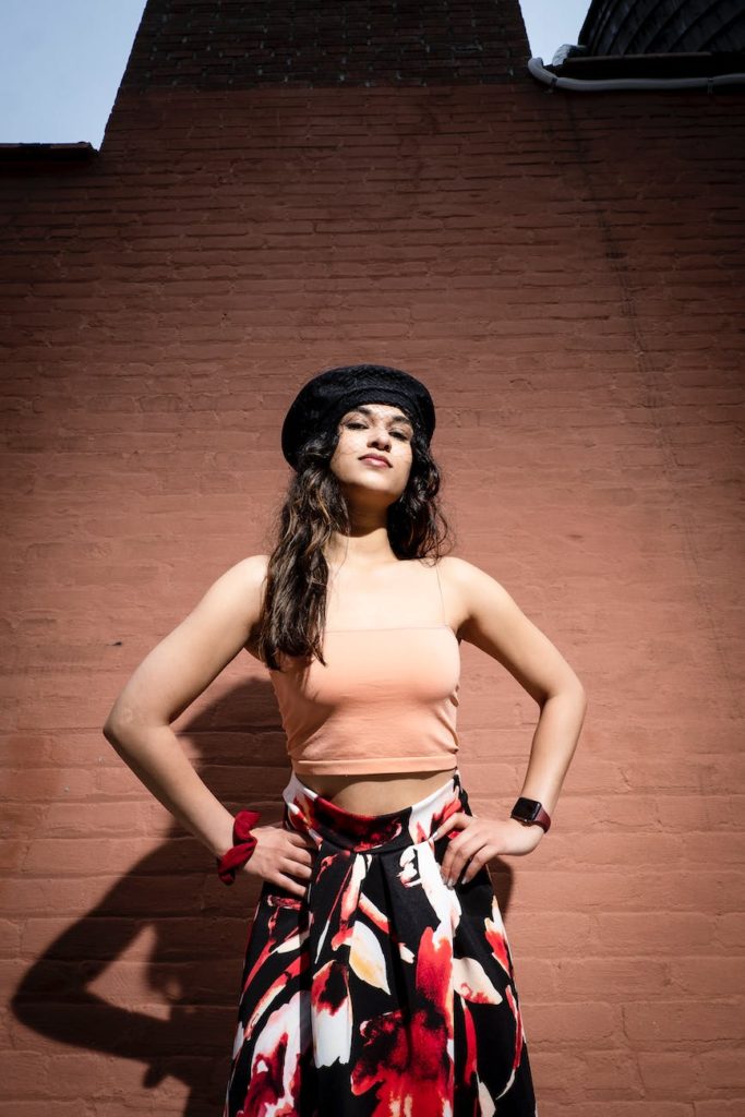 woman in a black hat standing with her hands on her hips