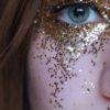 close up photo of woman with gold glitters on her face