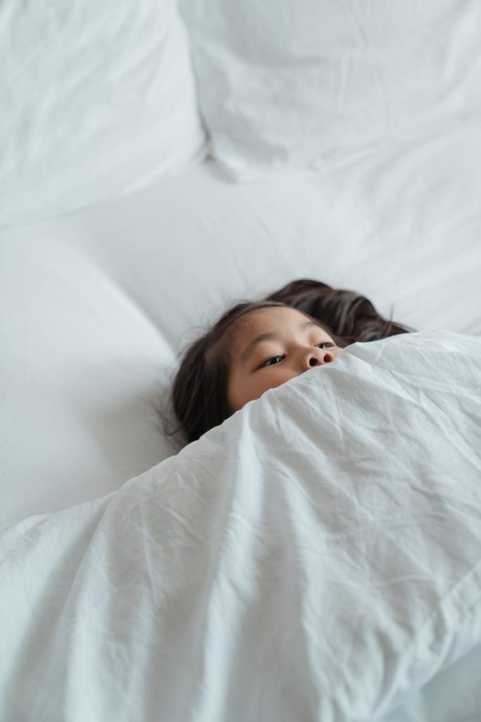 girl lying on white bed