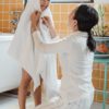asian mom tenderly wiping little daughter with bath towel