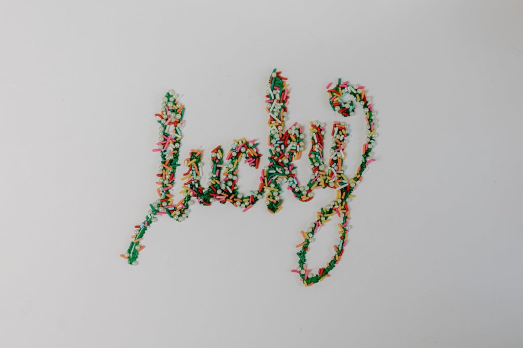 green icing text with colorful sprinkles