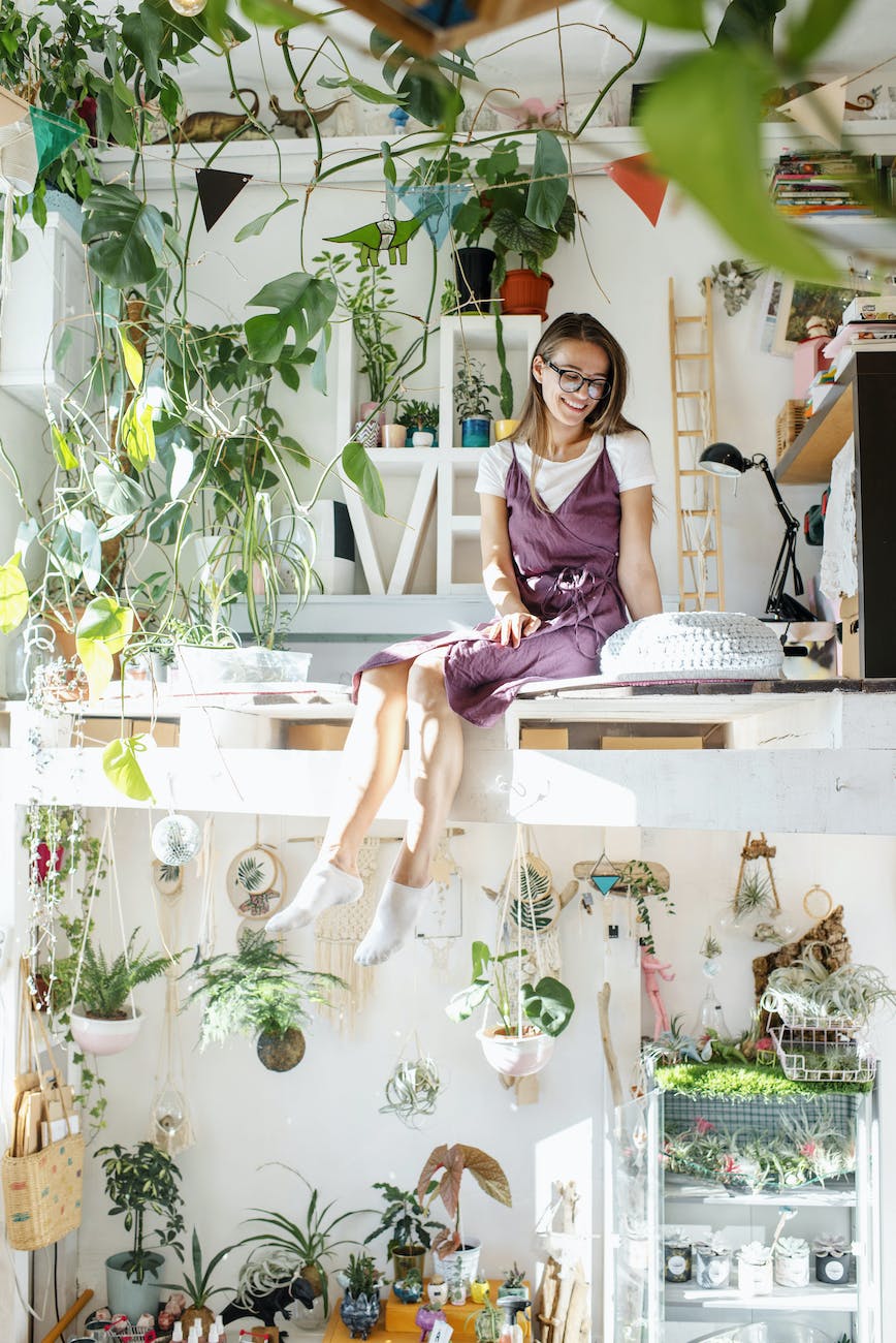young woman sitting in apartment on second level with plants