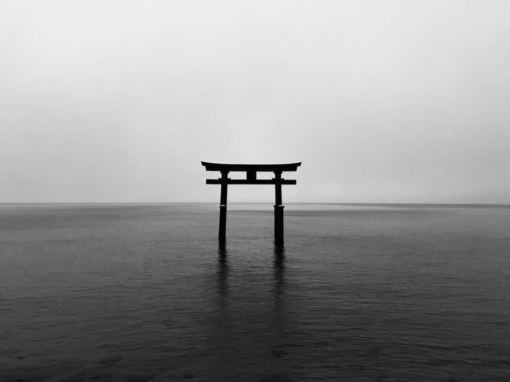 body of water surrounded by foggy sky