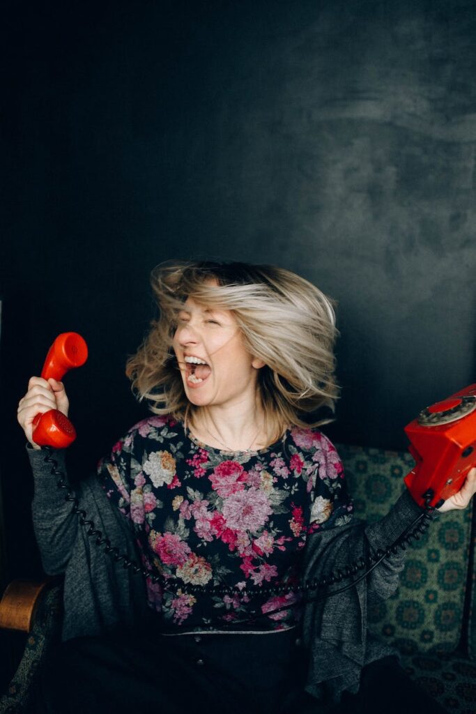 woman in floral shirt holding a phone