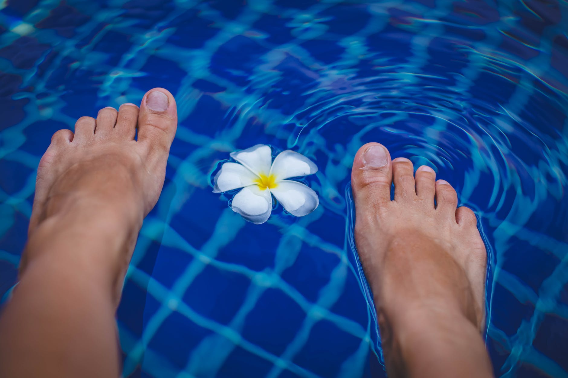 person s feet on swimming pool