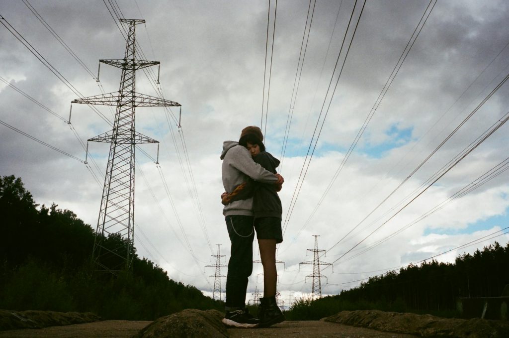 romantic couple hugging under the cloudy sky
