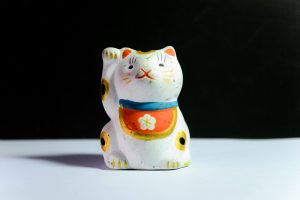 maneki neko figurine on white surface